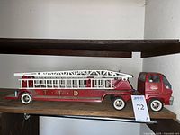 Side view of the vintage Tonka fire engine truck with the white metal ladder on red trailer body and 'T-F-D' lettering.