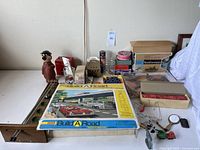 Wide view of all items on table showing games, boxes, and bank figurine