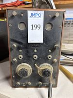 Front view of the vintage amplifier showing control knobs, input/output ports, and company labeling.