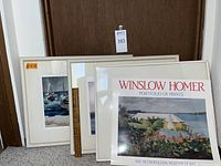 Photo showing several framed prints and the Winslow Homer portfolio leaning against a door.