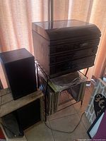 Stereo record player system stack with two separate speakers beside it.