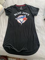 Full view of black women's T-shirt dress with 'BLUE JAYS' text and logo front and center, showing overall condition and shape.