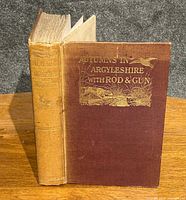 Front and spine view of the hardcover book with dark brown cloth and gilt embossed title and bird imagery.