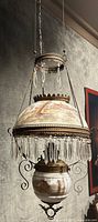 Full front view of hanging lamp showing hand-painted shade, crystal prisms and upper chain suspension
