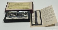 Photo of the original box with the label showing information about the Keystone Eye Comfort Series Stereoview Cards and the cards stacked next to it along with explanatory paperwork.