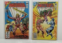 Front cover of Masters of the Universe Comics #1 and #3 side by side in protective sleeves.