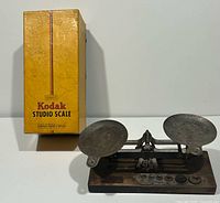 Full view of Eastman Kodak Studio Scale with two metal pans and original yellow Kodak box standing adjacent