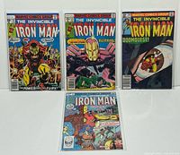 Four Marvel The Invincible Iron Man comics shown bagged and boarded, standing upright, with visible front covers.