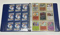 Blue binder with plastic sleeves holding Pokémon cards, showing backs and fronts of some cards.