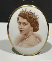 Clear frontal shot of the oval plaque showing detailed sepia portrait of Queen Elizabeth wearing tiara, gold edge trim visible