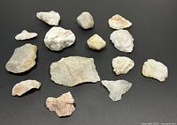 Full collection of 13 natural quartz stones varying in size and color on black background