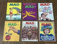 Six vintage Mad Magazine issues laid out, showing colorful and varied 1960s-1970s cover art.