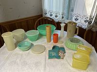 Full table view of Original Tupperware items showing bowls, pitcher, cups, jello mold, and containers.