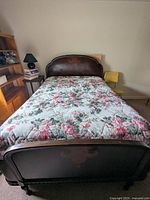 Full front view of Victorian wooden bed frame with floral mattress included, showing footboard and headboard.