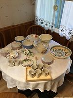 Table set with full assortment of vintage tea set items including teapots, teacups, plates, bowls, bunny figurine, and large fruit bowl.