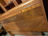 Wooden headboard showing full view of geometric chevron wood veneer pattern with central decorative inlay.