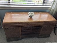 Chest closed under window, showing top veneer finish and overall condition