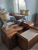 Vanity and bench viewed from corner showing mirror, lamps, and curved drawers on sides