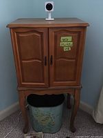 Front view of wooden jewelry cabinet with closed doors showing size and style
