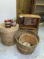 Photo showing three nested wooden baskets alongside assorted vintage tin containers placed on cardboard tubes.