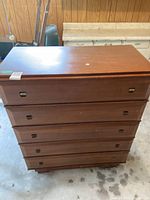 Front view of the 5-drawer dresser showing recessed handles and wood grain finish.