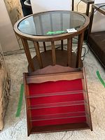 Round glass top side table showing the wood slatted base and round bottom shelf