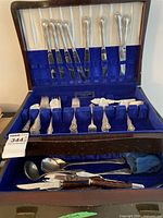 Open wooden canteen showing top rack of ornate knives and bottom compartment with forks, spoons, ladle and faux tortoiseshell-handled knives