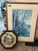 Framed print of Trilliums showing birch trees and white flowers by a river, in a gold frame with beige mat. Size noted 21x14.