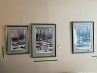 Three framed winter landscape prints by F. C. Keirstead hanging on a wall, showing different sizes and scenes.