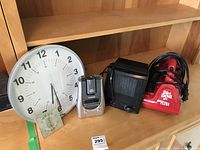Photo showing the full set of four items: large wall clock, digital clock radio, portable space heater, Dirt Devil handheld vacuum.