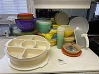 Overview of the assembled kitchenware set including bowls, segmented trays, containers, and metal grater.