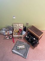 Overview photo showing Singer sewing machine, accessories including threads, needles, scissors, yarn, and storage case.