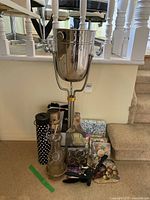 Full view of wine cooler on stand with bar accessories and napkins arranged at base.