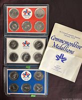 Three sets of commemorative medallions from the Edmonton 1978 Commonwealth XI Games along with informational pamphlets, showing the overall lot contents.