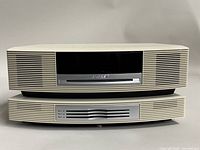 Front view of Bose Wave Music System main unit with central black display and cream speaker grilles