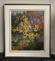Full view of framed Pauline Holancin oil painting depicting autumn trees by a shoreline with vibrant yellow and red leaves.
