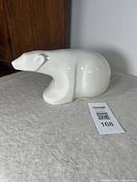 Front angle showing sleek glossy white ceramic polar bear figure with stylized forms and no damage visible.