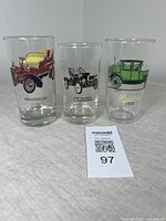 Front view of 3 high ball tumblers showing colorful vintage car designs: 1904 Cadillac, 1907 Maxwell, 1915 Studebaker.
