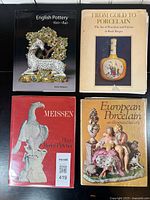 Four porcelain and pottery reference books arranged side by side on a black surface, showing front covers.
