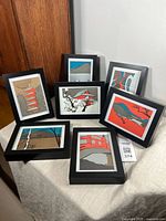Seven framed postcards with Japanese wood block print style artwork displayed on a table, arranged to show each design