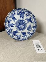 Front view of the scalloped antique porcelain plate showing six children playing around a bamboo motif and a central dragon medallion in blue underglaze.