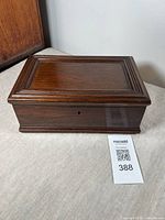 Closed antique mahogany box with smooth polished finish and carved lid edges.