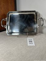 Full front view of rectangular silver plated serving tray with handles, showing overall condition and reflective surface.