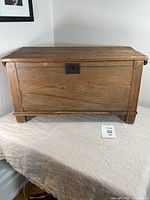 Front view of antique pine chest showing rectangular shape, keyhole escutcheon, and peg joinery.