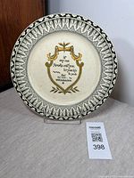 Photo of antique Royal Doulton plate showing front with green transferware border and central decorative shield with inscription text. Visible crazing on surface but no cracks or chips.