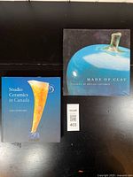 Image showing both ceramic reference books on a black surface with lot tag visible.
