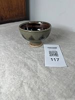 Photo of the footed glazed bowl from the side showing shape, glaze color and footed base