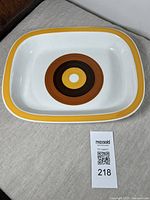 Top angle view showing the full rectangular platter with the yellow rim and concentric circle design in center.
