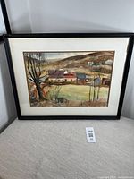 Full view of the framed watercolour landscape painting showing rural scene with trees and houses.