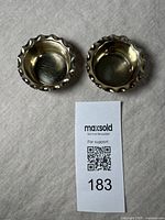 Pair of antique silver plate salts with gilt wash interiors seen from above on a neutral surface alongside a MaxSold support card.